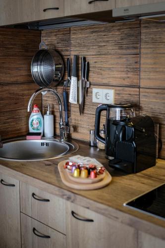 a kitchen counter with a sink and a plate of fruit at Agneta Apartamentai in Druskininkai