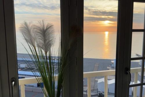 une plante dans une fenêtre avec vue sur l'océan dans l'établissement MH02 - L'évasion vue mer époustouflante, à Mers-les-Bains