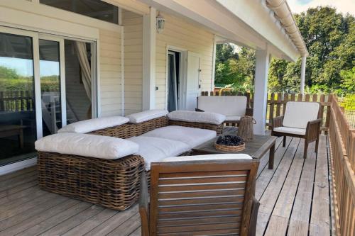 - une terrasse couverte avec un canapé et des chaises dans l'établissement Chalet Californien rénové, superbe piscine dans la résidence, central, ST Tropez 7km!, à Gassin