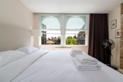 a white bed in a room with a window at 2 bedroom apartment in London Bridge in London