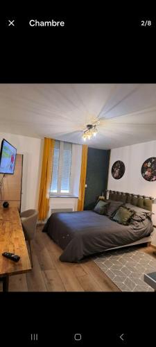 a bedroom with a bed and a desk and a television at Studio cosy in Villeneuve-sur-Lot