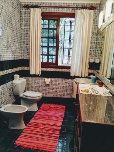 a bathroom with a white toilet and a sink and a tub at Beautiful Villa with Pool and Amazing Garden in Midlands Station