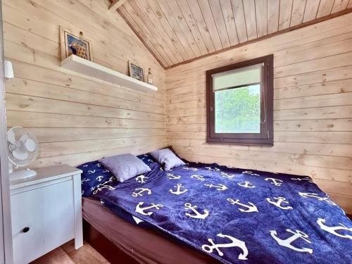ein Schlafzimmer mit einem Bett in einer Blockhütte in der Unterkunft Dębowy Zakątek in Olsztyn