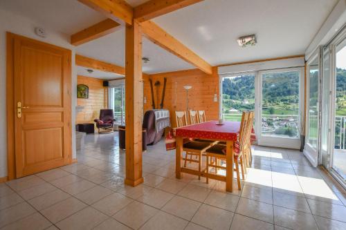 une salle à manger avec une table et des chaises rouges dans l'établissement Chalet de la Lunelle, à La Bresse