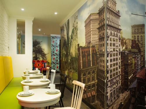 une rangée de tables dans un restaurant orné d'une fresque murale dans l'établissement Hôtel du Continent, à Paris