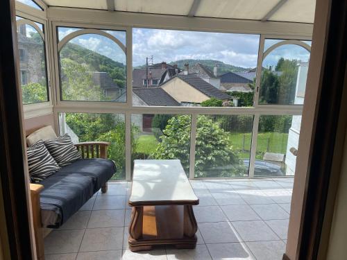 un salon avec un canapé et une grande fenêtre dans l'établissement Maison au cœur de ville, à Bort-les-Orgues