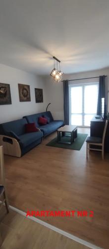 a living room with a blue couch and a table at PrzyLądek 30 in Lądek-Zdrój