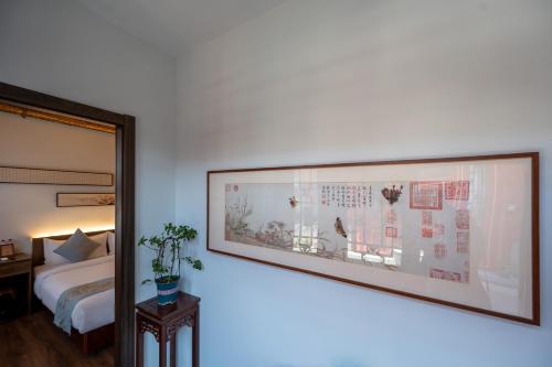 a large picture hanging on a wall in a bedroom at Beijing city center - Courtyard house hotel located in an ancient Hutong, near the Forbidden City,experience the lifestyle of old Beijing in the exquisite Chinese-style courtyard in Beijing