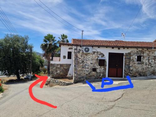 a house with two arrows in front of a street at THE ROCK HOUSE - Beautiful countryside with mandarins oranges and olive trees,. Near Limassol at Eptagonia village. in Ephtagonia