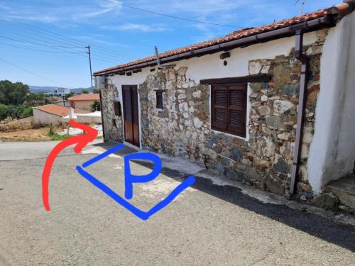 a stone house with a red arrow pointing to a house at THE ROCK HOUSE - Beautiful countryside with mandarins oranges and olive trees,. Near Limassol at Eptagonia village. in Ephtagonia