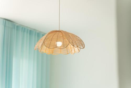 a pendant light hanging in front of a curtain at Milena Suite Apartments in Alghero
