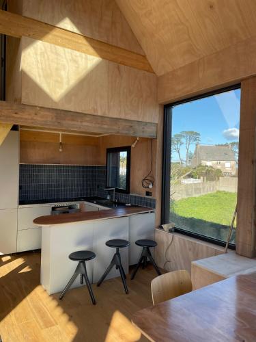 une cuisine ouverte avec une grande fenêtre et une table dans l'établissement Wooden architect-designed house, à Camaret-sur-Mer