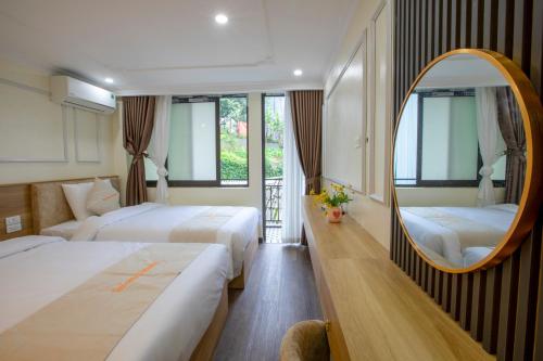 a hotel room with two beds and a mirror at Tom Central Homestay in Sapa