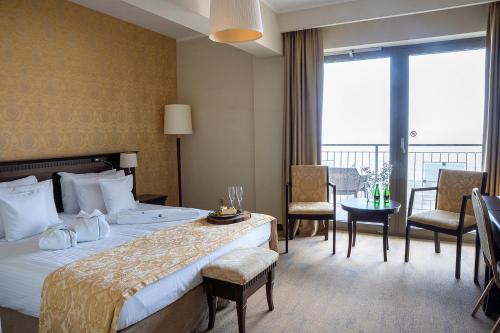 a hotel room with a bed and a table and chairs at Hotel Lambert Medical Spa in Ustronie Morskie