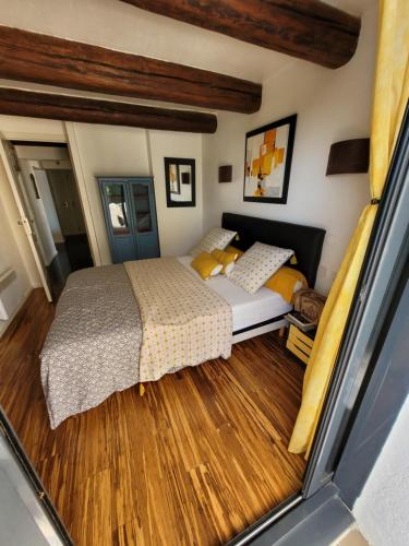 une chambre avec un lit et un parquet dans l'établissement leboncoin, à Pignan