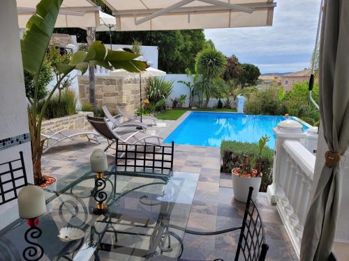 un patio avec une table et des chaises et une piscine dans l'établissement leboncoin, à Pignan