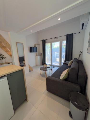 un salon avec un canapé et une table dans l'établissement Cyprès des cigales - Duplex meublé de tourisme, à Saint-Georges-dʼOrques