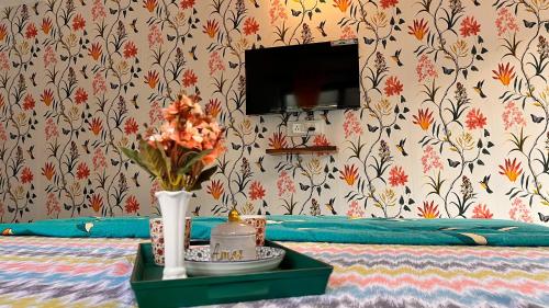 a room with a bed with a vase of flowers on a table at Peaceful Studios in Assagao in Parra