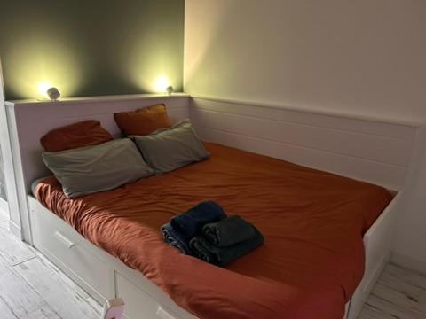 a bed with three pillows on it in a room at Le Bulloire in Montlouis-sur-Loire