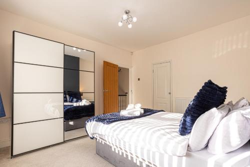 a bedroom with a large white bed and a mirror at Newly Refurbed 5 Bed House for Contractors, Families & Relocation- Cosely Wolverhampton in Coseley
