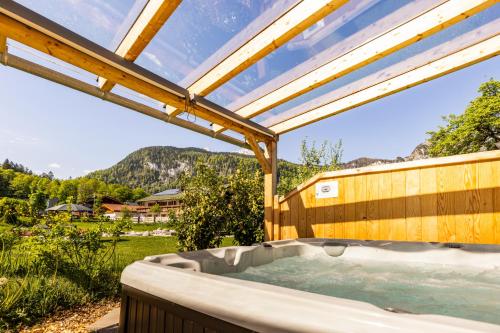 a hot tub in a backyard with a roof at Apart Chalet Unterbrandnerlehen in Schönau am Königssee