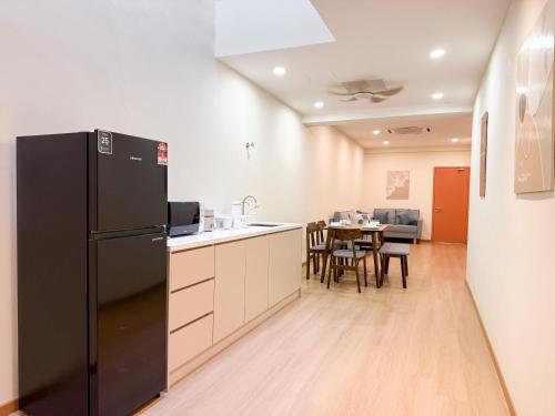 a kitchen with a black refrigerator and a table at Resandau Stay Ipoh - Nearby Ipoh Town - Private Car Park and Lift - Whole unit & Coliving in Ipoh