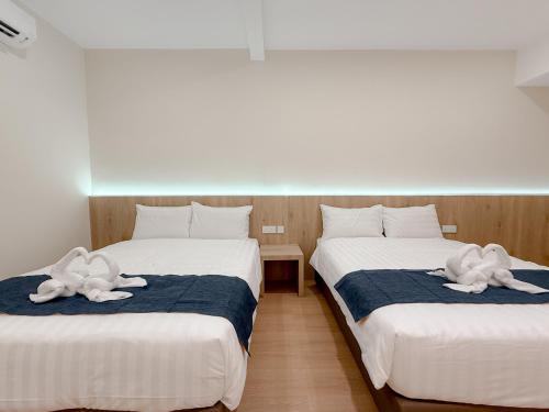 two beds in a room with towel animals on them at Resandau Stay Ipoh - Nearby Ipoh Town - Private Car Park and Lift - Whole unit & Coliving in Ipoh
