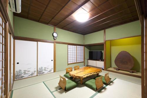 ein Raum mit Tisch und Stühlen und Fenstern in der Unterkunft 箱根 -桃源郷- 036h in Hakone
