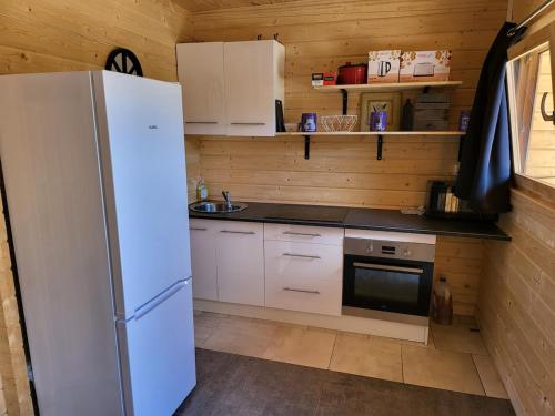 une cuisine avec un réfrigérateur blanc et un évier dans l'établissement La Belle brune, avec jacuzzi, à Alincthun