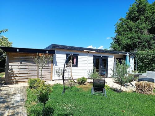 une maison dotée d'une cour avec une chaise en face dans l'établissement La Belle brune, avec jacuzzi, à Alincthun
