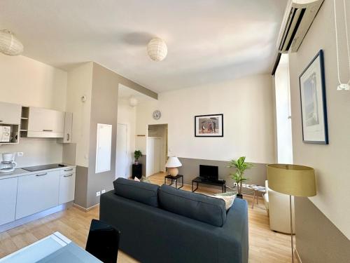 un salon avec un canapé et une cuisine dans l'établissement Magnifique 2 pièces - Hyper centre Nice, à Nice