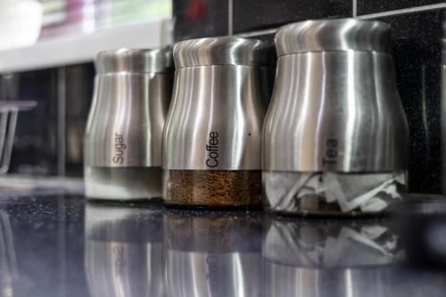 a row of spice bottles sitting on top of a counter at Newly Refurbed 5 Bed House for Contractors, Families & Relocation- Cosely Wolverhampton in Coseley