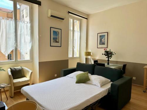 une chambre avec un lit, une chaise et une fenêtre dans l'établissement Magnifique 2 pièces - Hyper centre Nice, à Nice