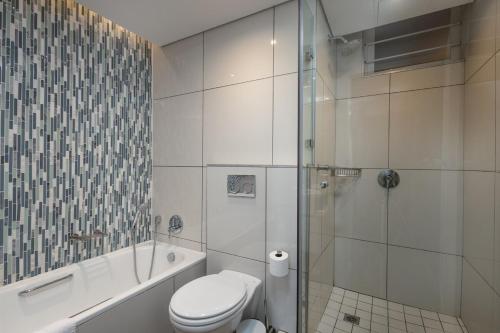 a white bathroom with a toilet and a shower at The Breakers 310 in Durban