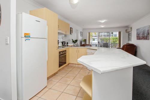 a kitchen with a white refrigerator and a counter at Blue Water Bay Luxury Villas - Southport in Gold Coast