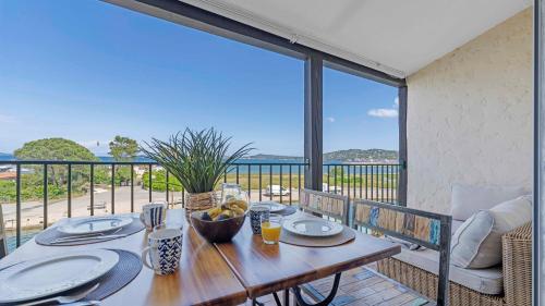 une table en bois sur un balcon avec vue sur l'océan dans l'établissement La VIGIE Port-Grimaud with view, à Grimaud