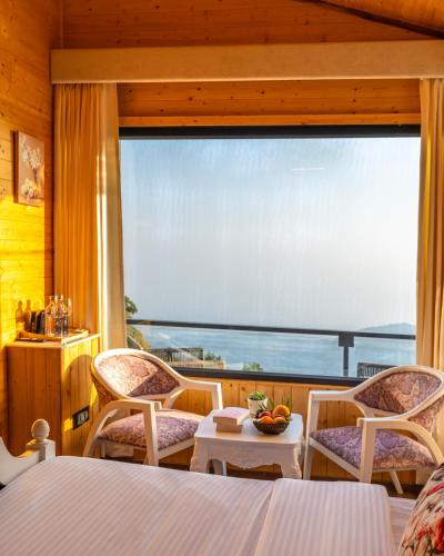 a bedroom with a large window with a view of the ocean at The English Country House in Mussoorie