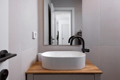 a bathroom with a white sink and a mirror at אורה דירות אירוח - 6006 - דירת 2 חדרי שינה וסלון מעוצבת אדריכלית במרחק הליכה מהים in Eilat