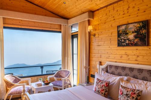 a bedroom with a bed and a view of the ocean at The English Country House in Mussoorie