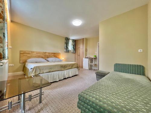 a hotel room with two beds and a table at White House Zalakaros in Zalakaros