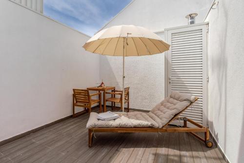 a patio with a chair and an umbrella and a table at HostWise - Modern & Bright Studio in Porto