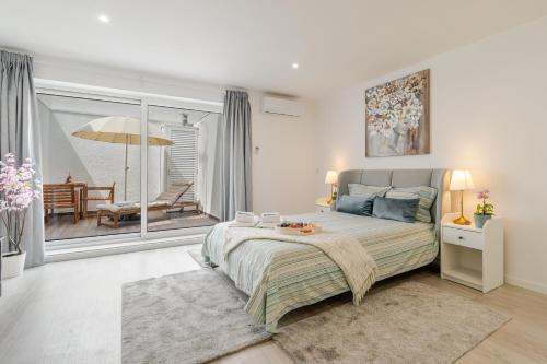 a bedroom with a large bed and a balcony at HostWise - Modern & Bright Studio in Porto