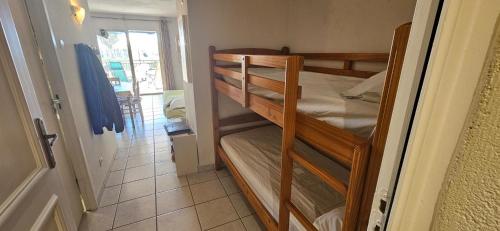 une chambre avec deux lits superposés dans une pièce dans l'établissement Palmeraie 131-Clim-PISCINE EN RESIDENCE, à Sari-Solenzara