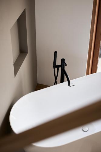 a black faucet sitting on top of a white sink at Colago Private Villas Lake Garda in Toscolano Maderno