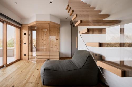 a living room with a staircase and a chair at Colago Private Villas Lake Garda in Toscolano Maderno