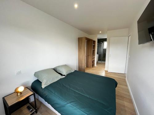 - une petite chambre avec un lit vert et une table dans l'établissement Villa Climatisée 8 Pers, 4 chambres, 3 Sdb, à Saubion