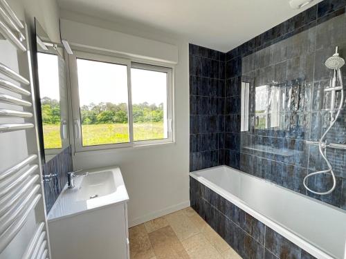 une salle de bain avec une baignoire, un lavabo et une fenêtre dans l'établissement Villa Climatisée 8 Pers, 4 chambres, 3 Sdb, à Saubion