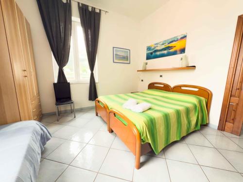 a bedroom with a bed with a green and yellow blanket at Excelsior Mare Suite in Ischia