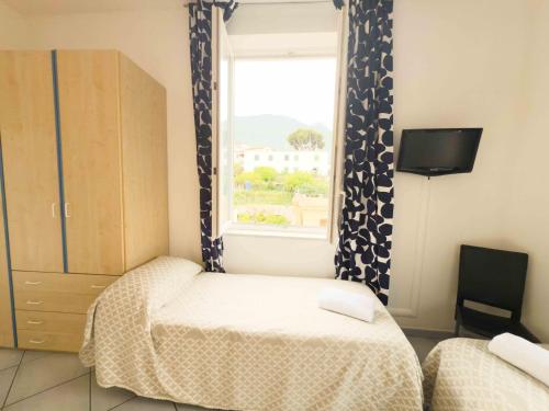 a small bedroom with a bed and a window at Excelsior Mare Suite in Ischia