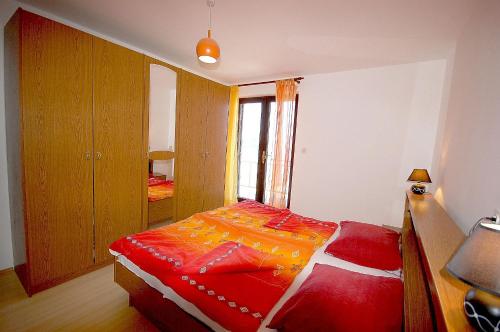 sypialnia z łóżkiem z czerwoną kołdrą w obiekcie Apartments Nikky by El-Pi Tours w mieście Malinska